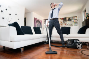 man sweating cleans the floor of the house